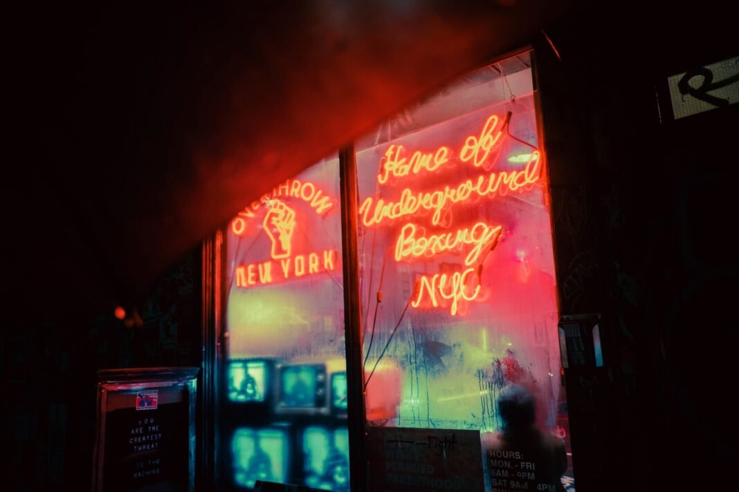 Dive bars East Village — neon-lit bar storefront window at night