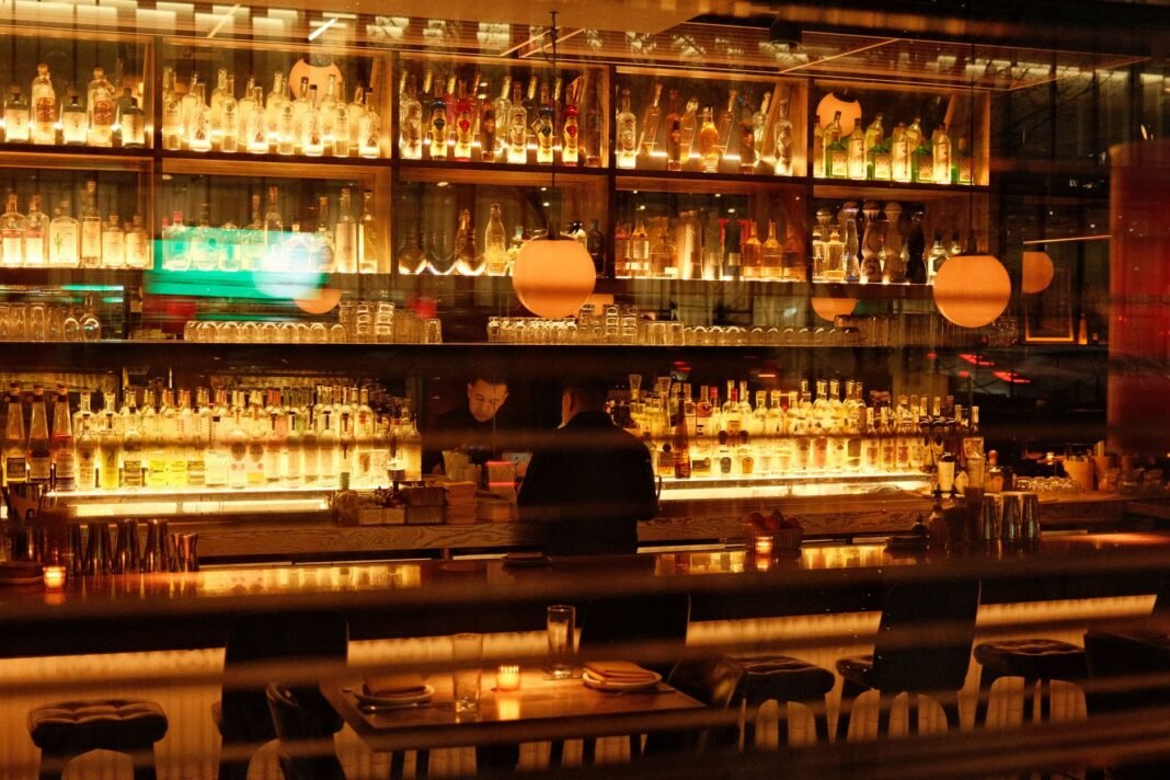Best wine bars in NYC — dimly lit bar interior with glowing bottle shelves